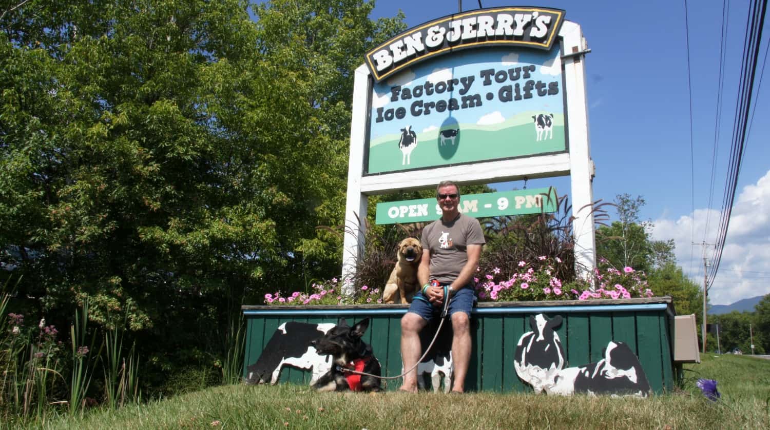 Man and two dogs with the sign at Ben and Jerry's - Burlington, VT
