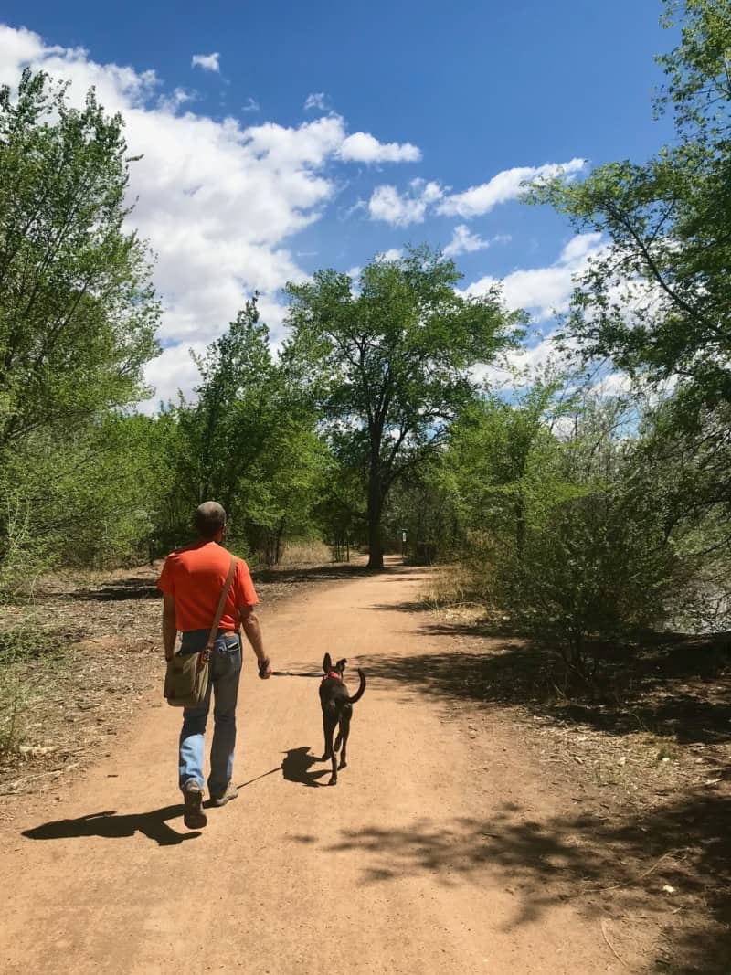 Man and dog walking on a pet friendly dirt trail in Albuquerque, NM