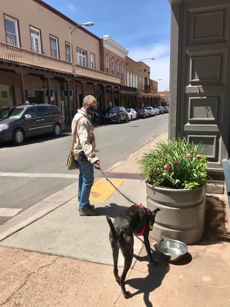 Man and dog walking down the sidewalk in pet friendly Santa Fe, NM