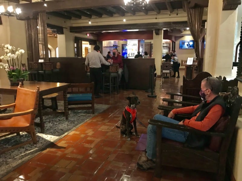 Man and dog sitting in the lobby at La Fonda on the Plaza in Santa Fe, NM