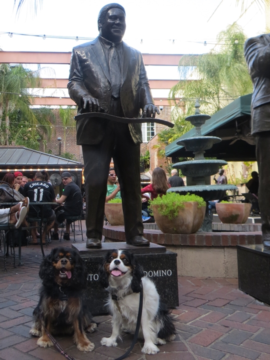 Two dogs posing in front of a statue of "Fats" Domino in Musical Legends Park - Pet Friendly New Orleans, LA