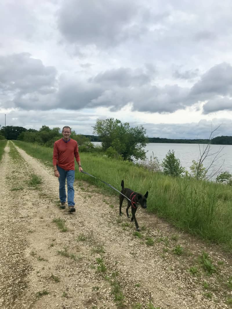 Man and dog walking pet friendly trail at Trempealeau National Wildlife Refuge in Wisconsin