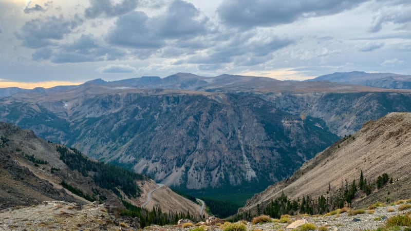 View looking down at the winding Beartooth Highway with mountains in the background.