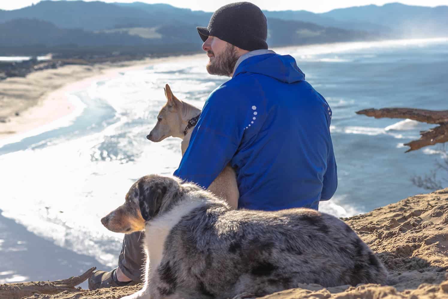 Man in hat with two dogs enjoying ocean views along pet-friendly Oregon Coast