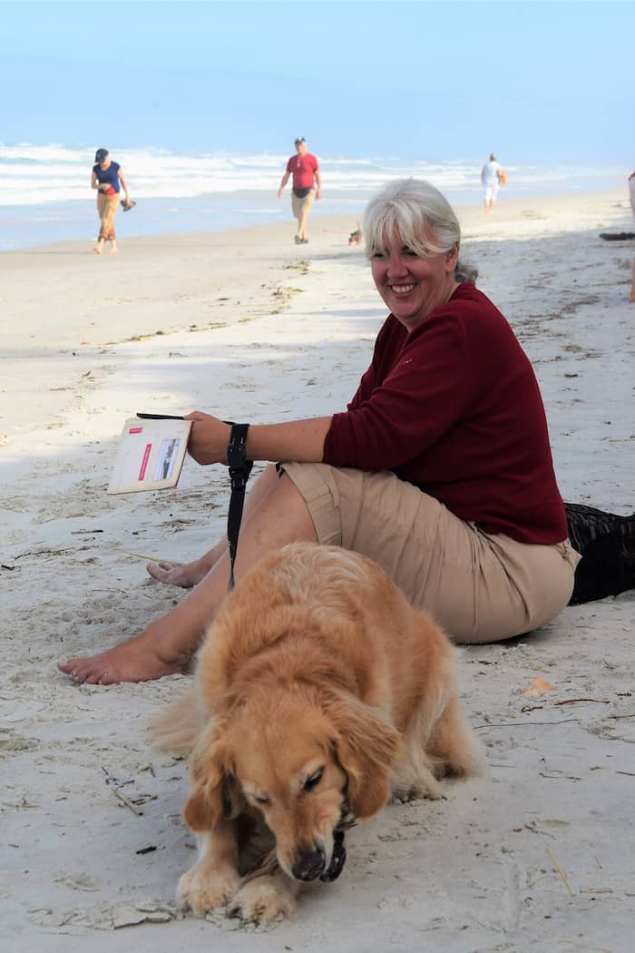 Honey the golden retriever and Pam wait on the beach at Fort Matanzas.