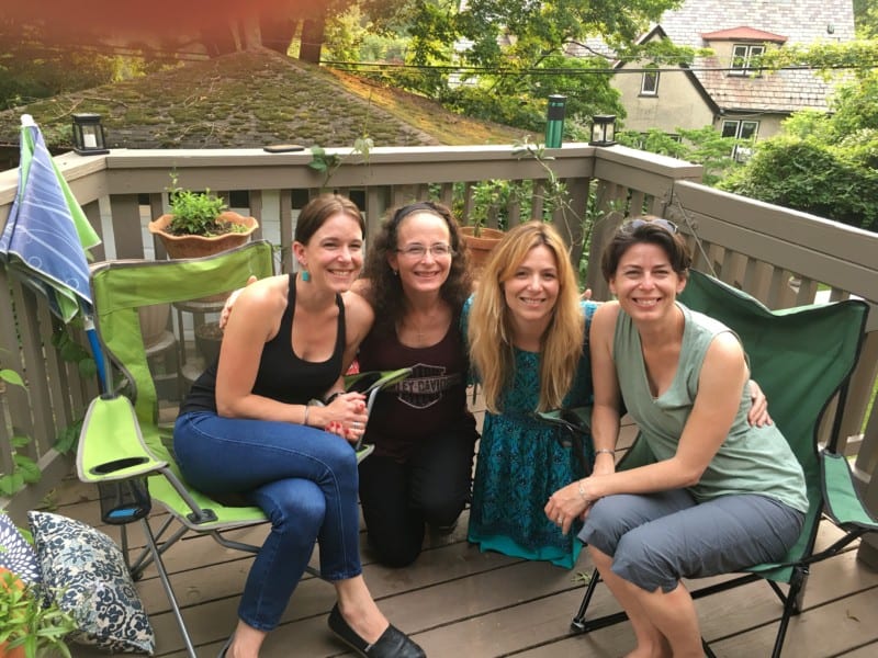 Four sisters smiling on an outdoor deck in summer