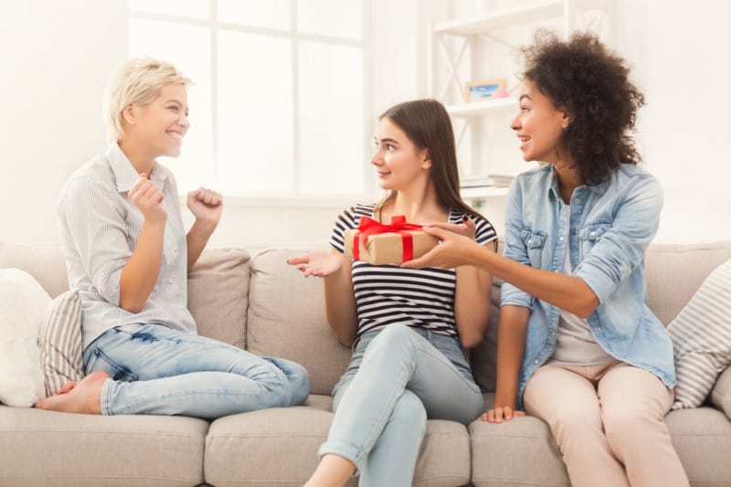 Excited woman getting gift from her friends
