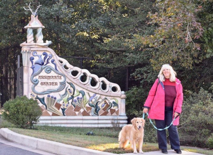 Visiting a pet-friendly museum is a great way to make the most of your vacation. (woman and golden retriever in front of ornate gate)
