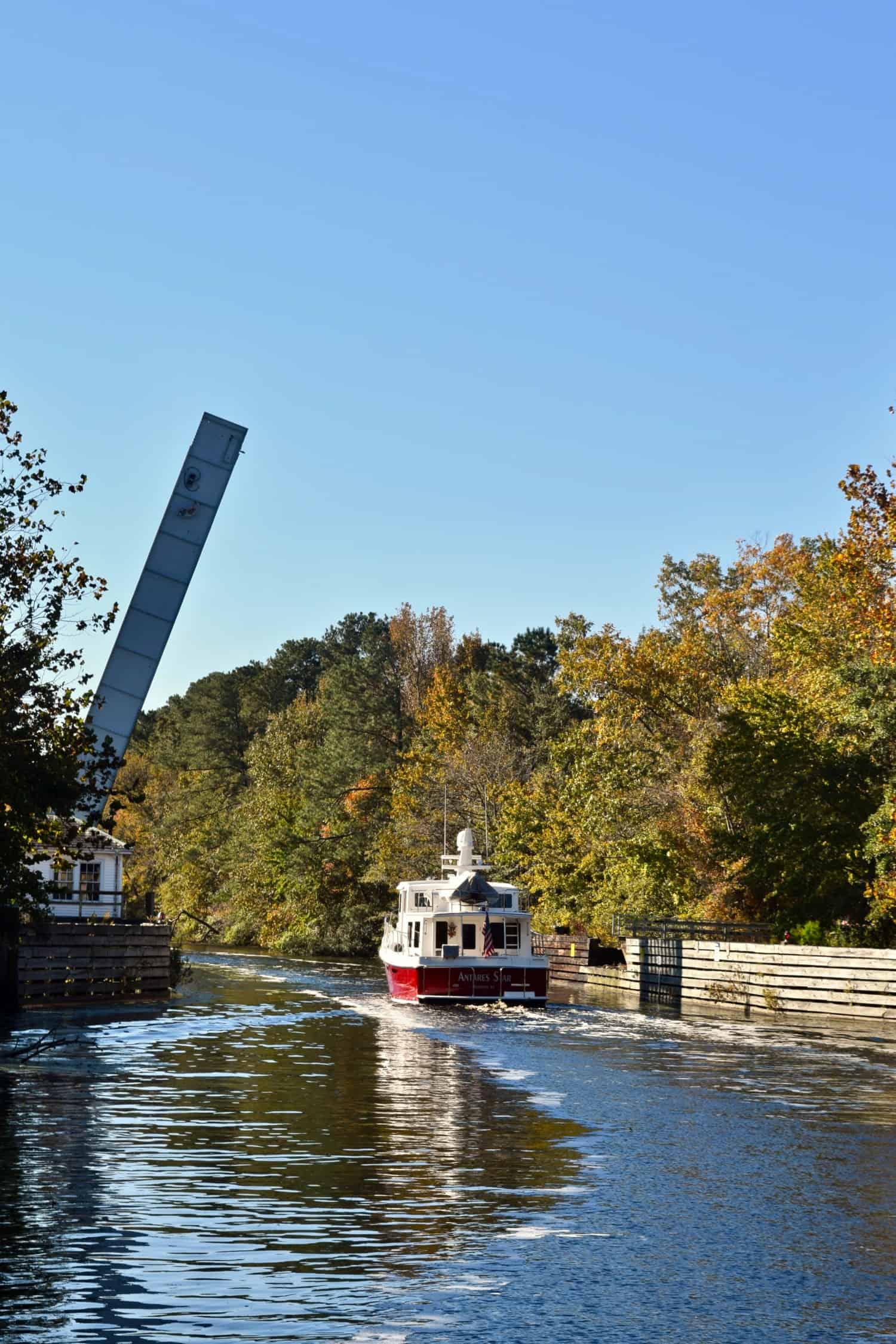 Red and white boat passing through the Bascule Bridge in the Great Dismal Swamp