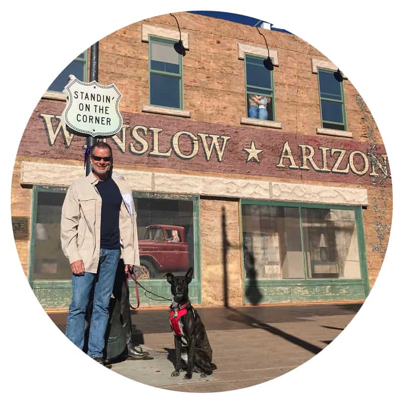 Man and a dog standing on the corner in Winslow, AZ