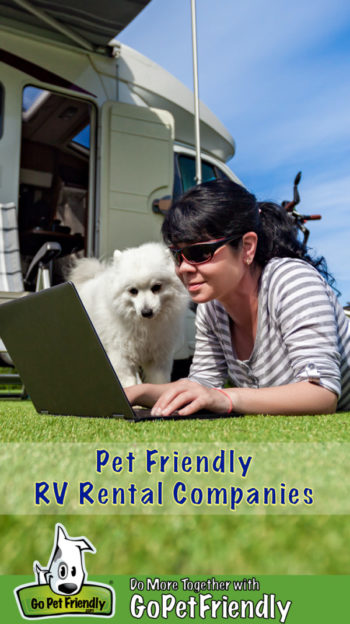 Woman laying in the grass with a dog in front of a pet friendly RV rental