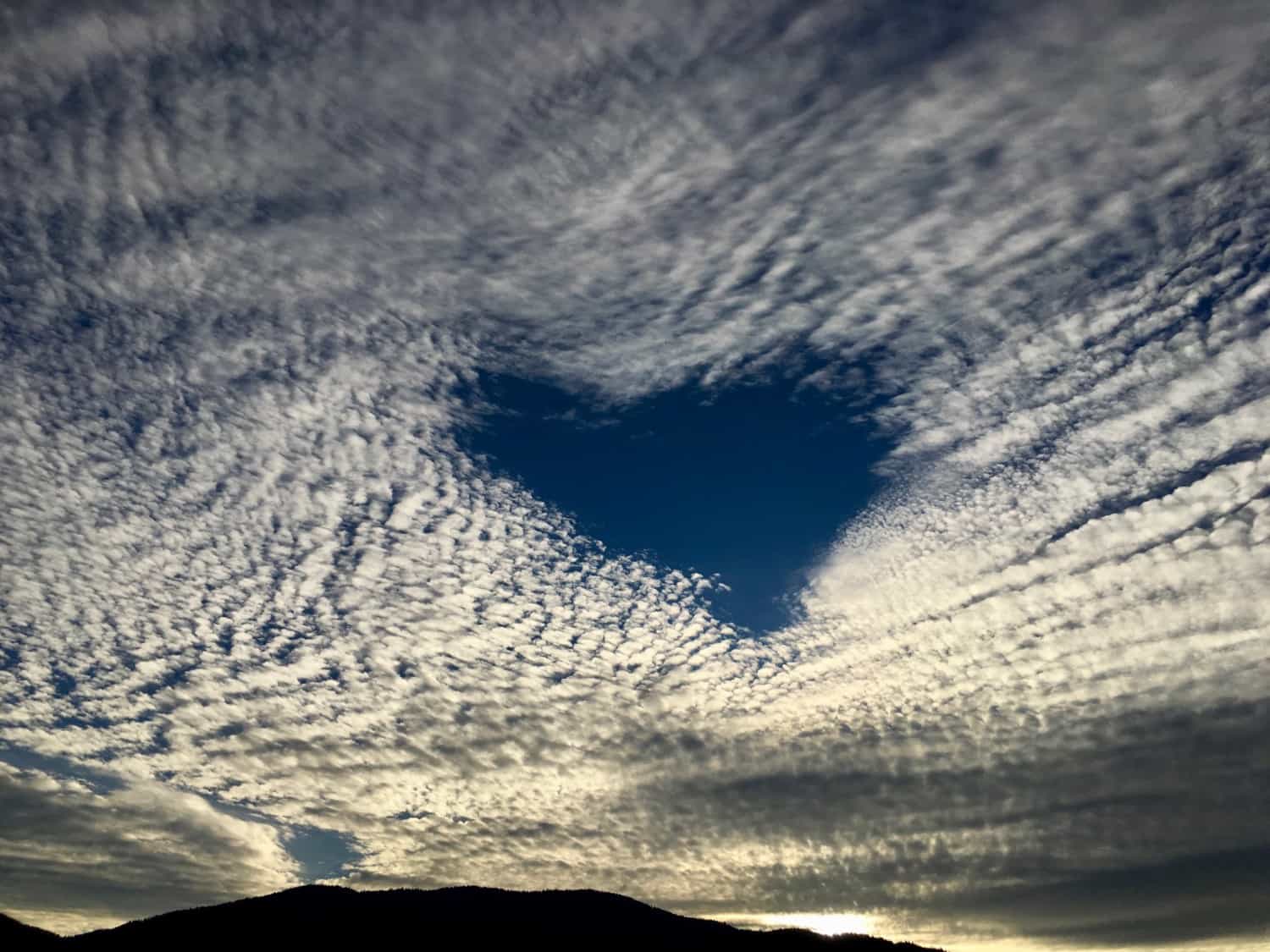 Heart-shaped hole in a cloudy sky