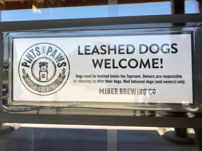 Leashed dogs welcome sign at pet friendly Miner Brewing Company in Hill City, SD