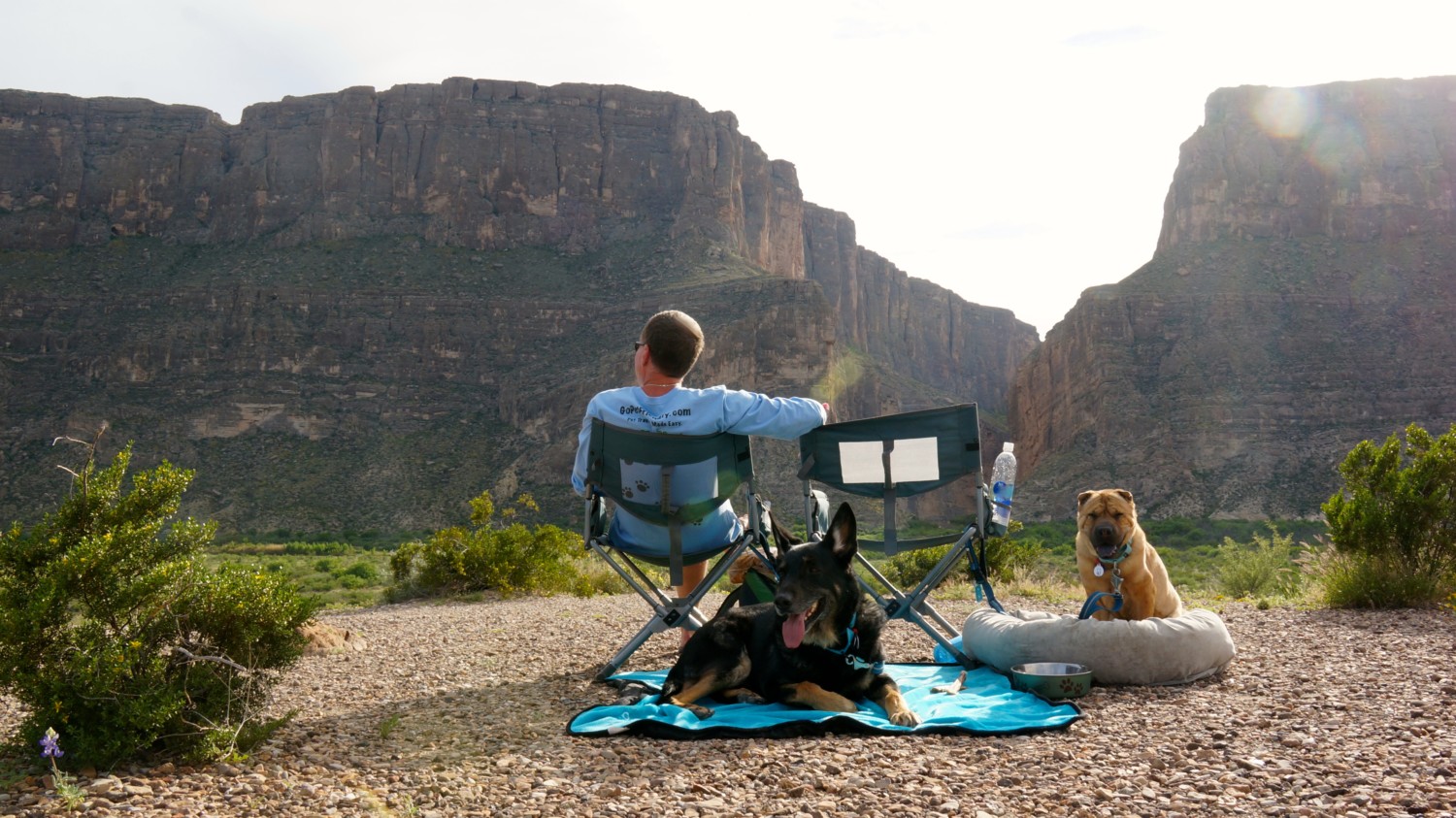 Man in a chair with two dogs at Santa Elena Canyon in Big Bend National Park, Texas