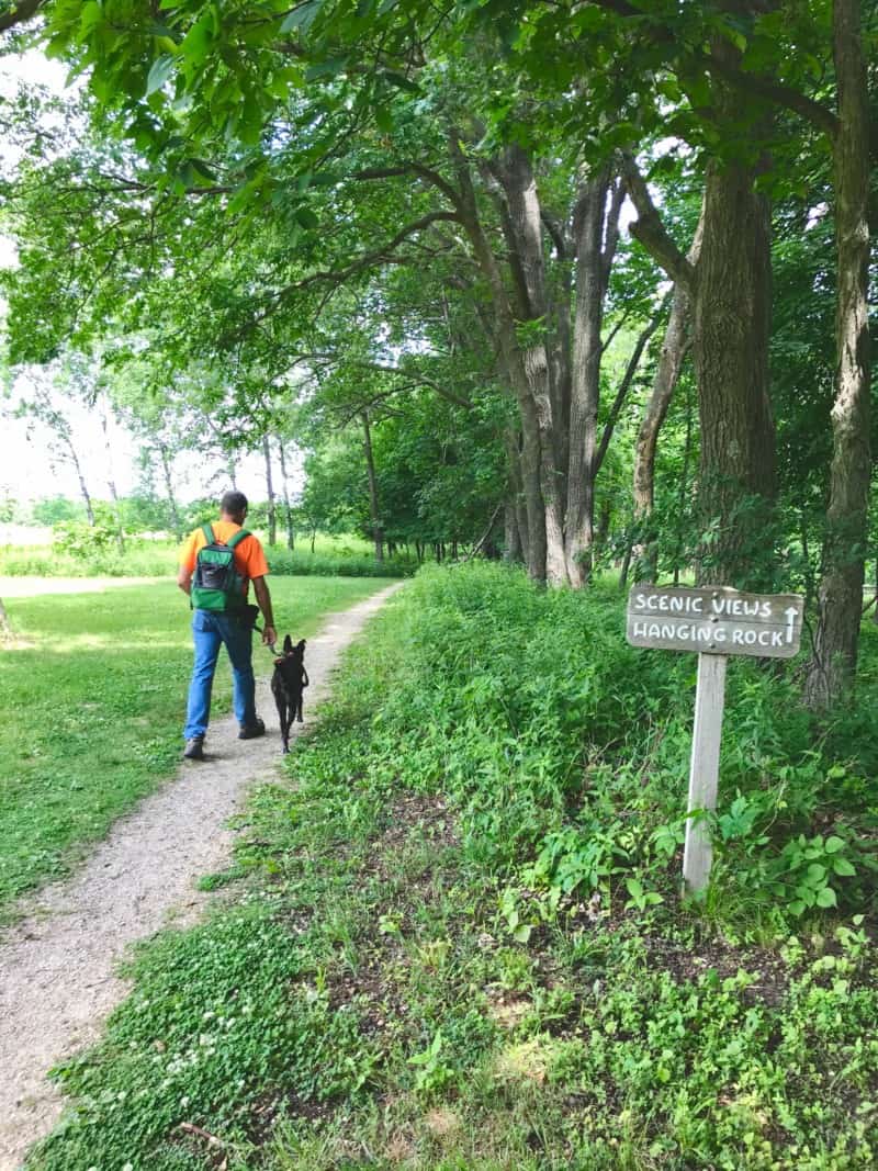 Man walking dog on trail at Effigy Mounds National Monument in Iowa