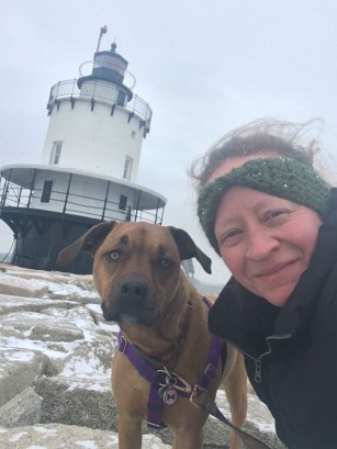 Woman and dog at a pet friendly lighthouse in New England