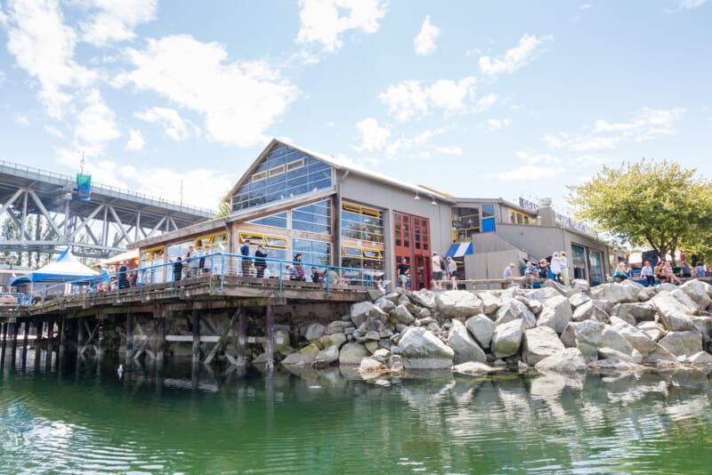 Visitors resting at the Granville Island Public Market. It's home to over 100 vendors offering fresh seafood, meats, and specialty foods. Granville Island is located across False Creek from downtown Vancouver.