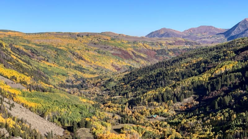 Mountain landscape with golden aspen trees and evergreens