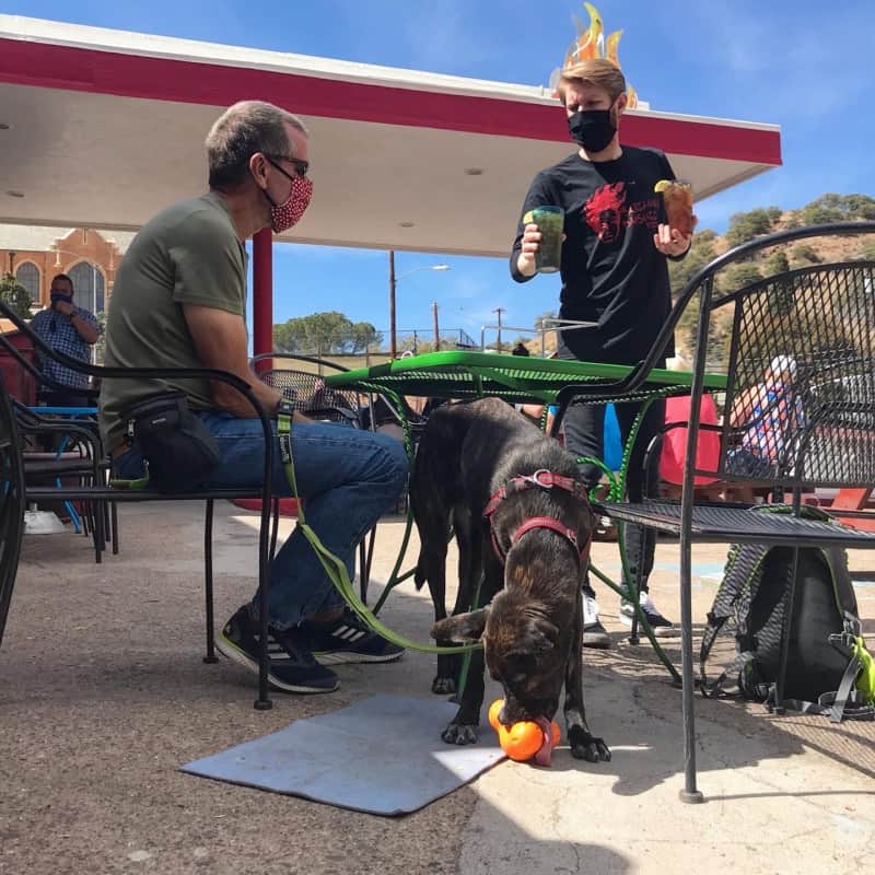 Waiter serving drinks at a pet friendly table at Screaming Banshee Pizza in Bisbee, AZ