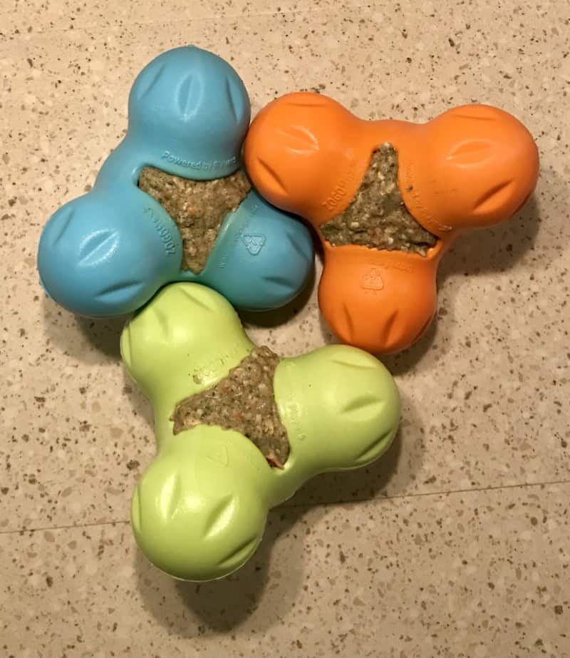 Three West Paw Zygoflex dog toys stuffed with Honest Kitchen dog food and ready for the freezer