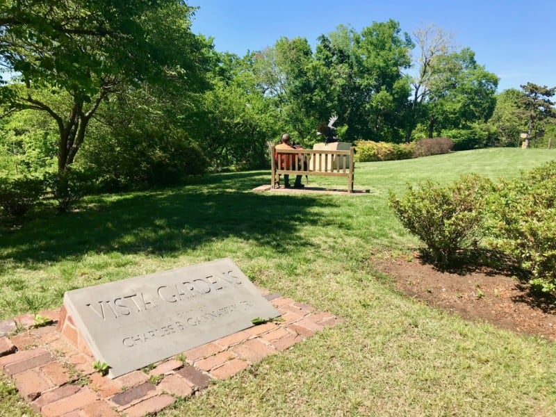 Man and dog on a bench at the pet friendly Gilcrease Museum gardens in Tulsa, OK