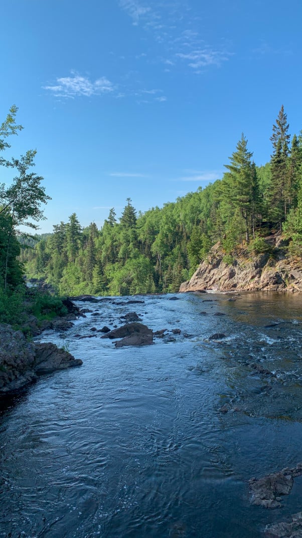 View of a river at the top of a waterfall with pines trees in the background at Tettegouche State Park on the North Shore in Minnesota