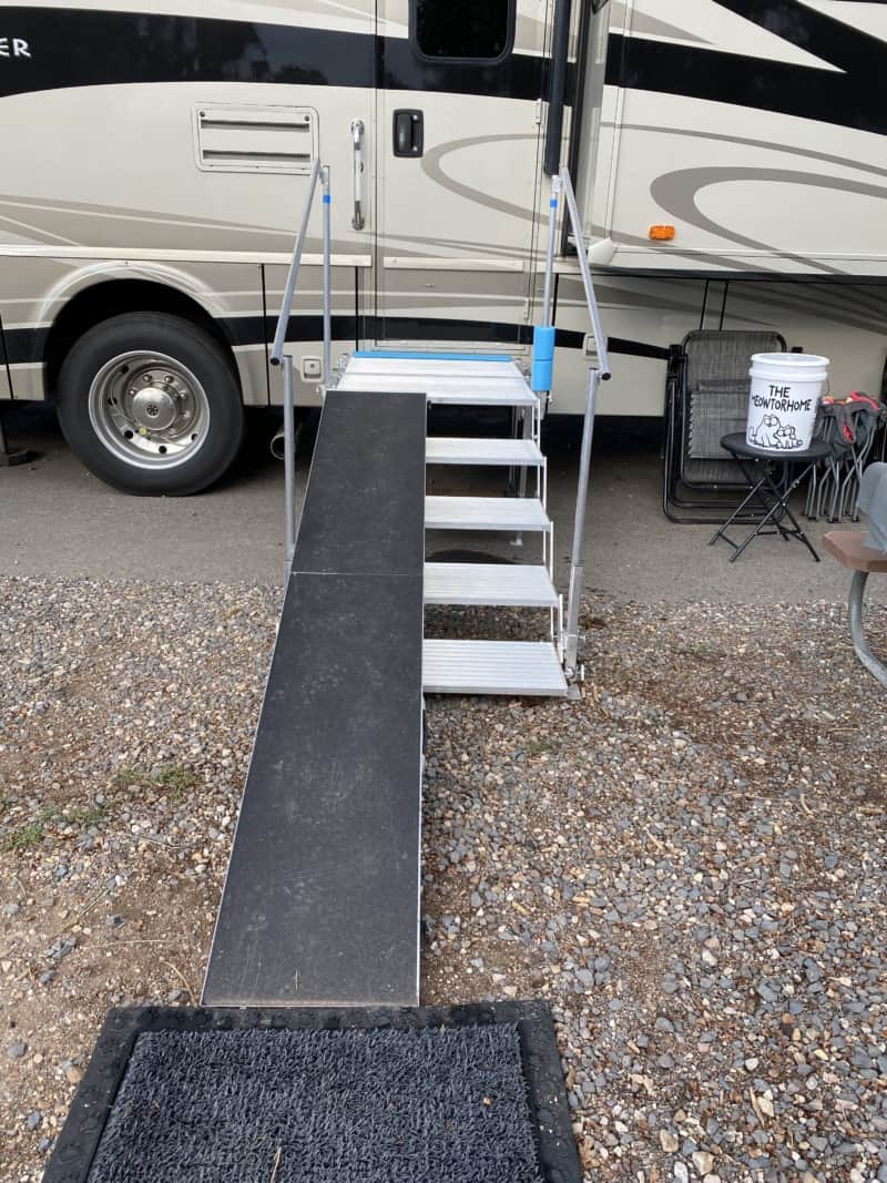 Folding deck and stairs with a dog ramp set up against a motorhome