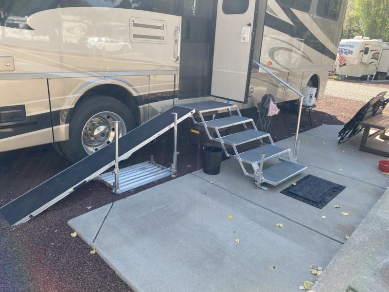 Folding stairs with a dog ramp set up against a motorhome