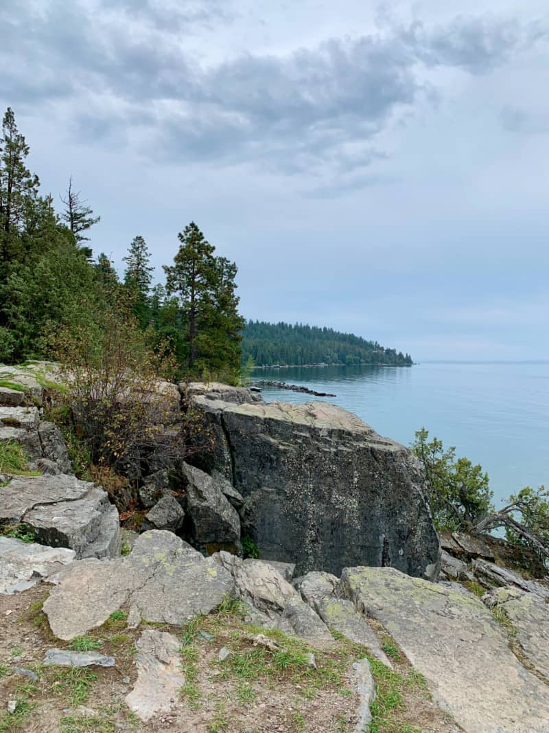 View of the rocky, pine covered shoreline of Flathead Lake, Montana