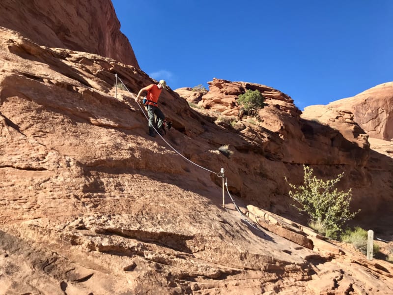 Man and dog on pet friendly Corona Arch Trail in Moab, UT