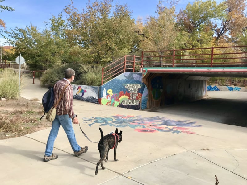 Man walking dog on Mill Creek Parkway in Moab, UT