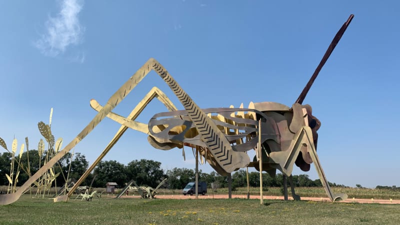 A large metal sculpture of a grasshopper