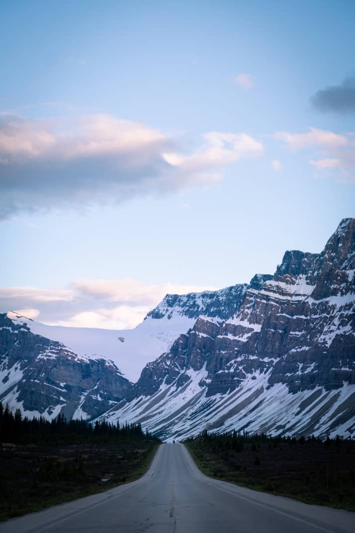 Road leading into enormous mountains in Banff.