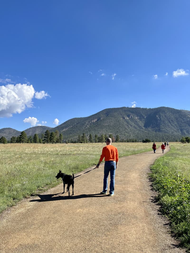 Man and dog walking on the Nate Avery Loop Trail in Buffalo Park - Flagstaff, AZ