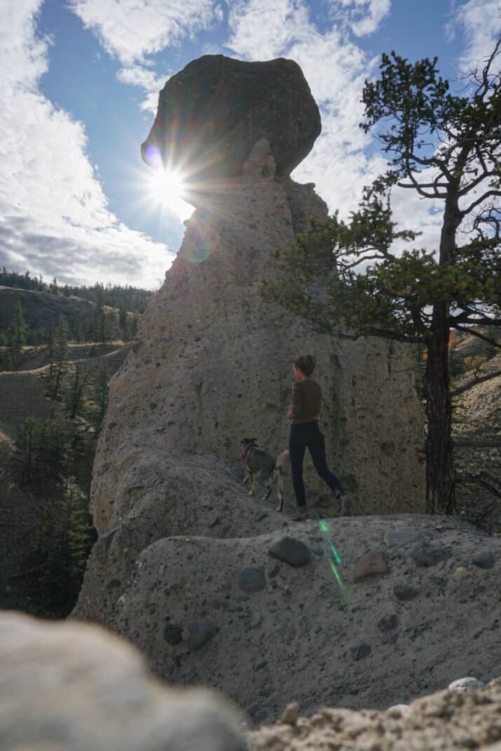 Hiking in Kamloops, BC. Woman walking her dog amongst hoodoos.