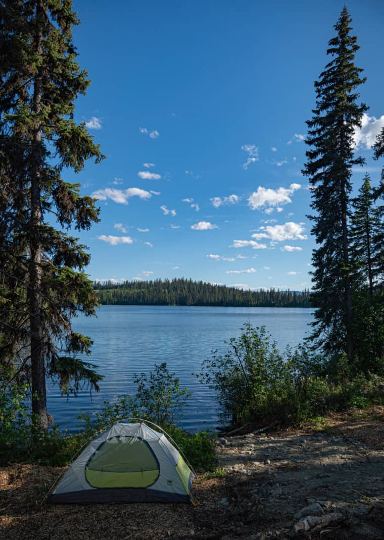 Free campsite on a Vancouver to Kamloops circle tour road trip. A grey and green tent pitched next to a lake near Clearwater, BC.