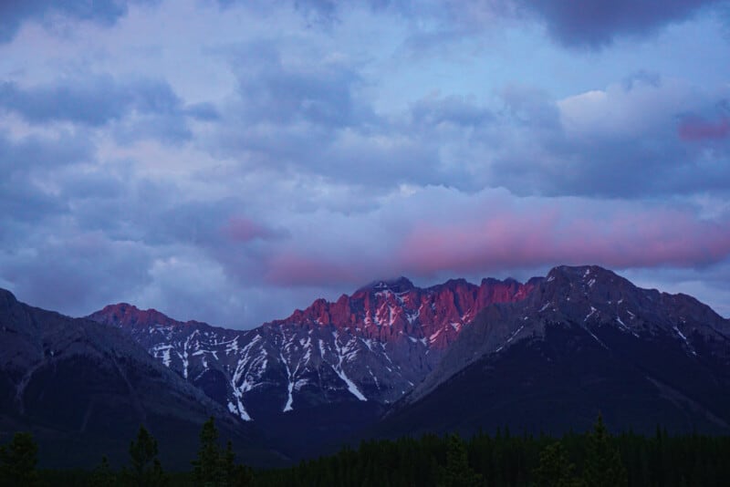 Sunset glowing on Jasper mountains creating snowy pink peaks.